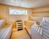 Dřevěná sauna s lavicemi a oknem.