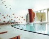Moderní wellness centrum s bazénem a lehátky.