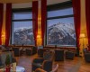 Hotelový salónek s výhledem na zasněžené hory.