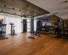 Moderní fitness centrum s různým cvičebním vybavením na dřevěné podlaze.
