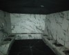 Místnost s mramorovými stěnami a lavicí.