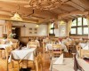 Elegantní restaurace s dřevěným stropem a prostřenými stoly.