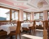 Elegantní restaurace s dřevěným nábytkem a prostřenými stoly poblíž oken.