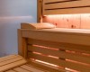 Dřevěná sauna s lavicemi a jemným osvětlením.