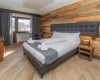 Moderní ložnice s dřevěnými stěnami a velkou postelí.