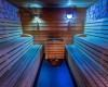 Dřevěná sauna s osvětlením a lavicemi na obou stranách.