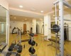 Posilovna s různým cvičebním vybavením, včetně činek a běžeckých strojů.