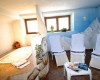 Relaxační místnost se třemi lehátky, stolkem s časopisy a vířivkou, dekorovaná nástěnnou malbou hor.