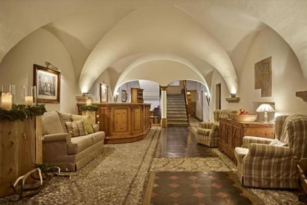 Elegantní lobby s klenutými stropy, dřevěnými prvky a pohodlnými sedačkami.