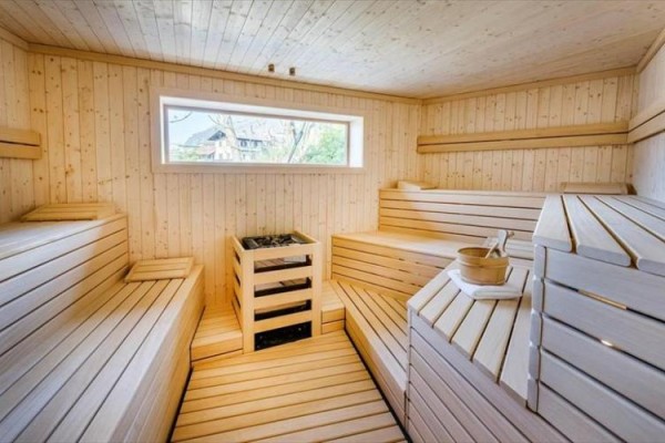 Dřevěná sauna s lavicemi a oknem.