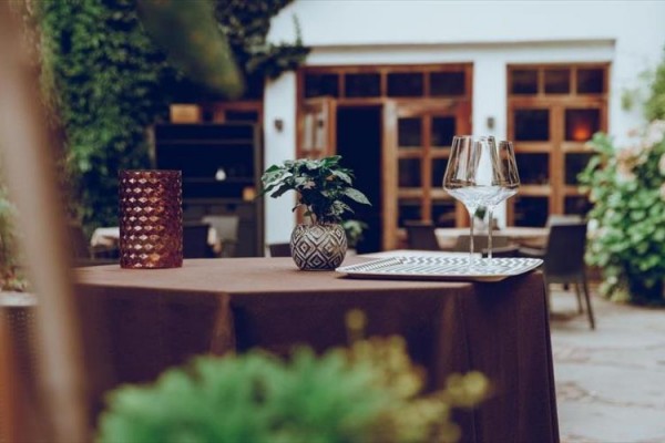 Stůl v zahradní restauraci s dekoracemi a sklenicemi na víno.  