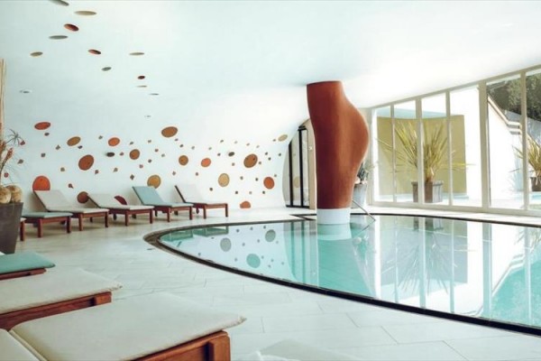 Moderní wellness centrum s bazénem a lehátky.