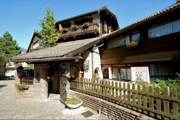 Venkovský hotel s dřevěnými balkóny a květinovou výzdobou.  