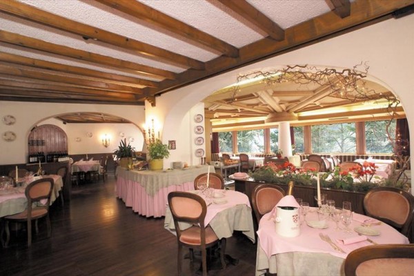 Restaurace s dřevěným stropem, upravenými stoly a růžovým dekoracemi.