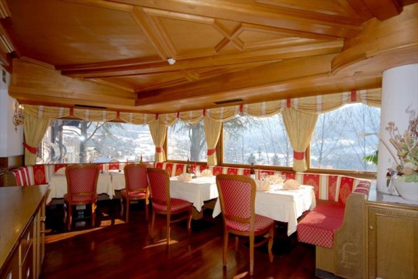 Restaurace s dřevěným interiérem a výhledem z velkých oken.