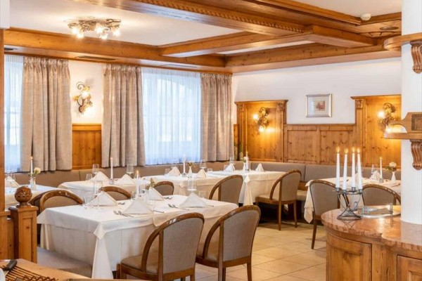 Restaurace s dřevěným obložením a prostřenými stoly.