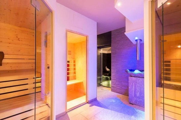Sauna a wellness místnost s moderním osvětlením a dřevěným interiérem.