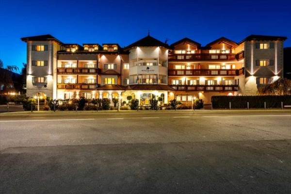 Zářivě osvětlená budova hotelu během noci.