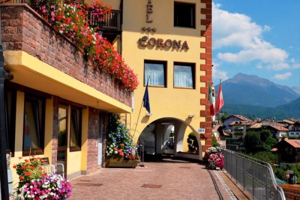 Budova hotelu s květinami na balkonech v horské oblasti.