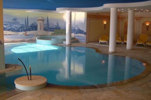 Luxusní krytý bazén s vířivkou a relaxačními lehátky.
