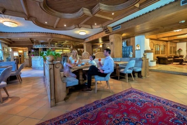 Rodina sedí u stolu v rustikální restauraci.