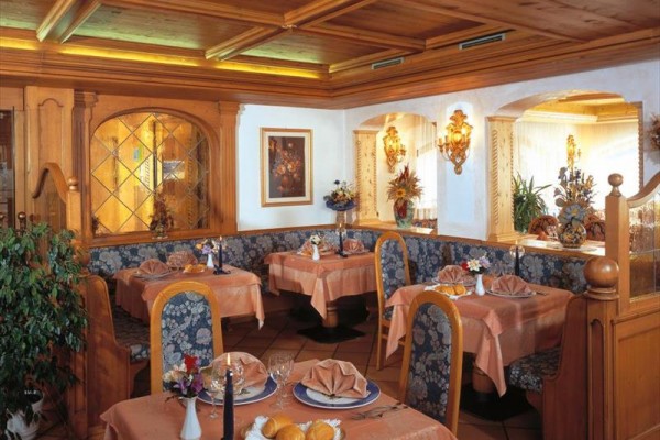 Stylová restaurace s dřevěným obložením a prostřenými stoly.