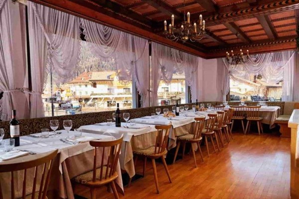 Restaurace s prostřenými stoly a výhledem z oken na město.