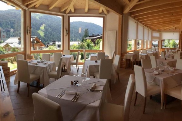 Elegantní restaurace s velkými okny a výhledem na hory.