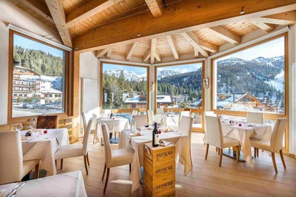 Restaurace s prostřenými stoly a výhledem na zasněžené hory.