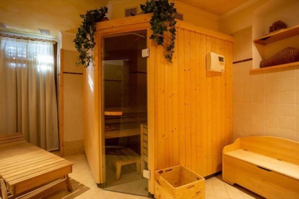 Dřevěná sauna v útulné místnosti s lehátkem.
