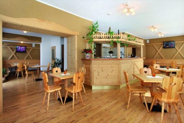 Restaurace s dřevěným nábytkem a barem.