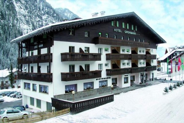 Hotel s dřevěnými balkony v zasněžené horské krajině.  
