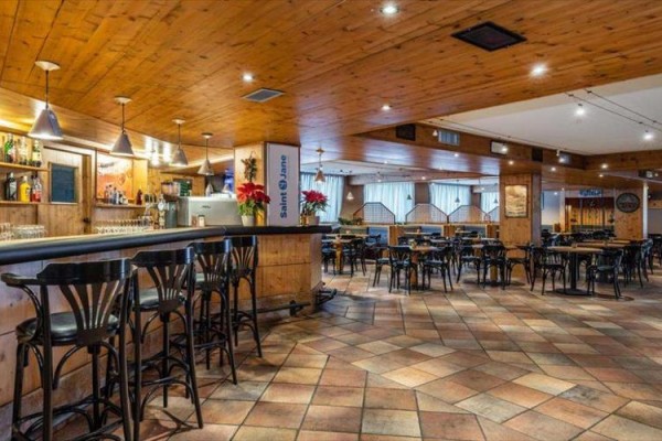 Interiér prázdné restaurace s dřevěnými stropy a podlahami.