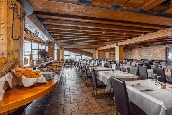 Restaurace s prostřenými stoly a bufetovým stolem plným jídla.