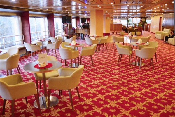 Luxusní hotelová lobby s červeným kobercem a béžovými křesly.