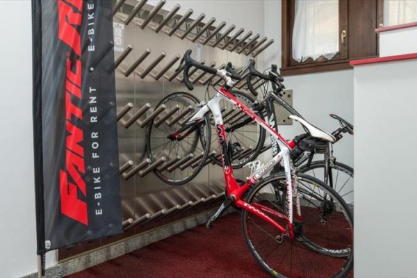 Stojan s cyklistickými koly vedle bannery s nápisem 