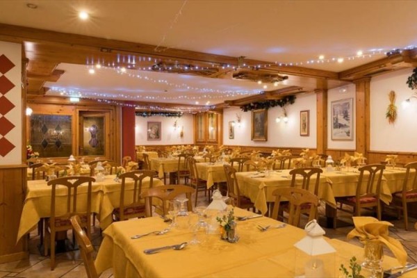 Restaurace s dřevěným interiérem a žlutými ubrusy na stolech.