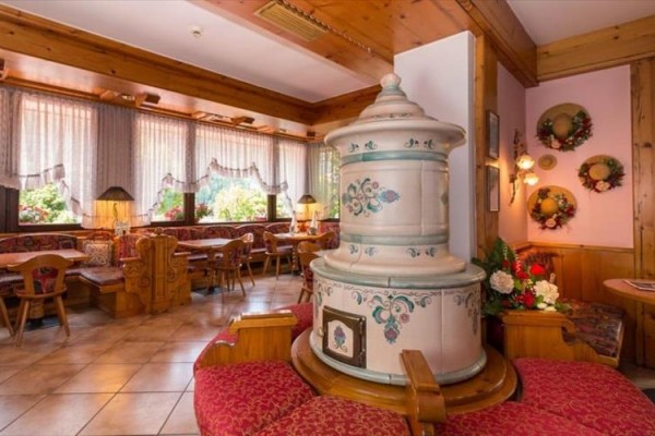 Stylová restaurace s dřevěným interiérem a tradiční keramickou kachlovou pecí.