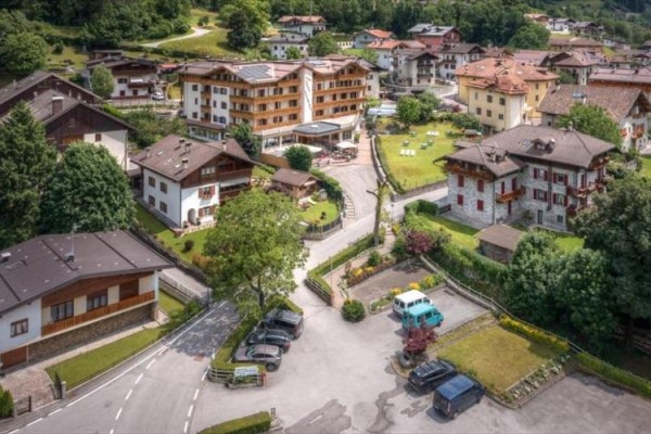 Letecký pohled na malebnou alpskou vesnici s domy a zelení.