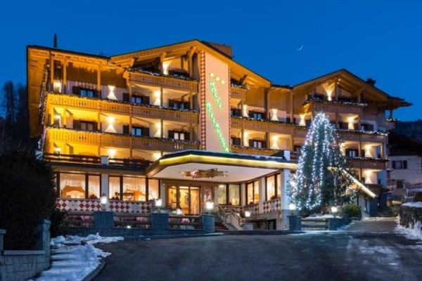 V noci osvětlený horský hotel s vánočními dekoracemi.