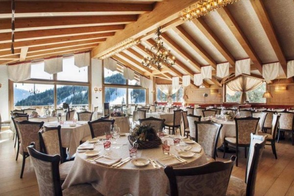 Restaurace s dřevěným stropem a prostřenými stoly.