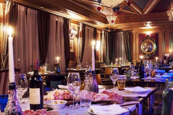 Luxusní restaurace s prostřenými stoly a tlumeným osvětlením.