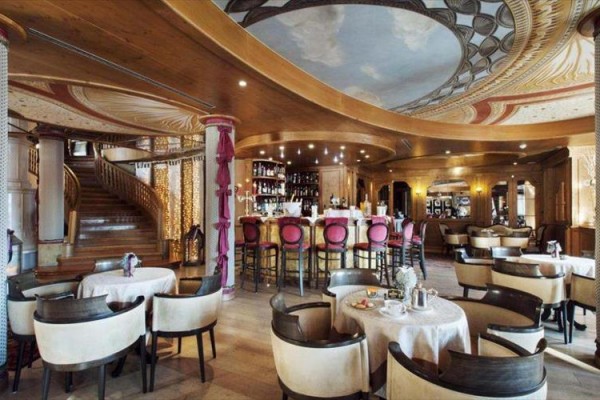 Luxusní restaurace s kruhovým barem a malovaným stropem.