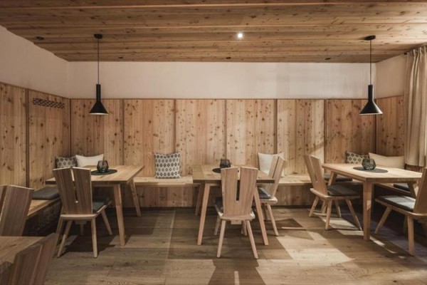 Dřevěná restaurace s jednoduchým nábytkem a osvětlením.