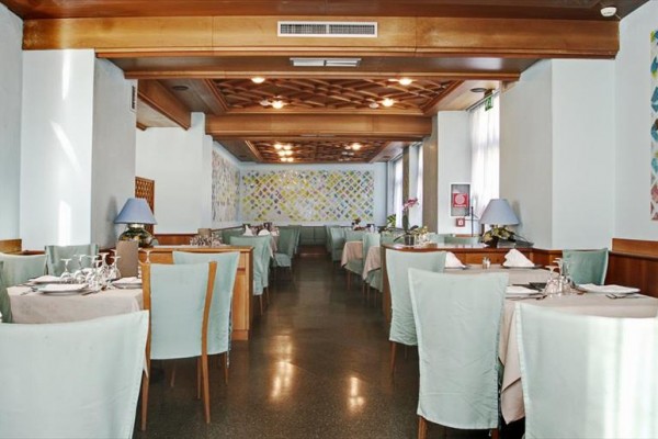 Elegantní restaurace s pastelovým nábytkem a ubrusy.