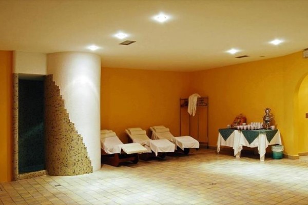 Spa místnost s lehátky a občerstvením na stole.