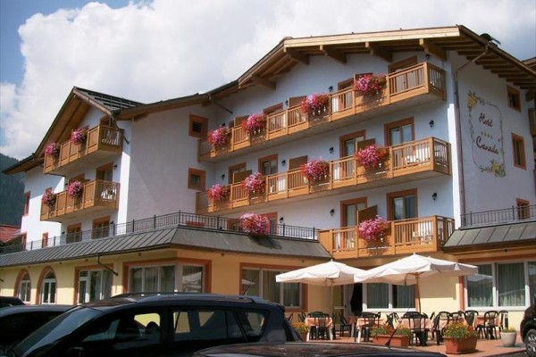 Třípatrový hotel s dřevěnými balkony zdobenými květinami.