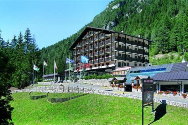 Hotel obklopený zelenými lesy v horské krajině.