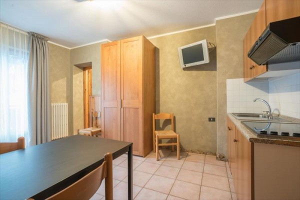 Ložnice s manželskou postelí, stolem a dvěma nočními stolky v jednoduchém moderním stylu.