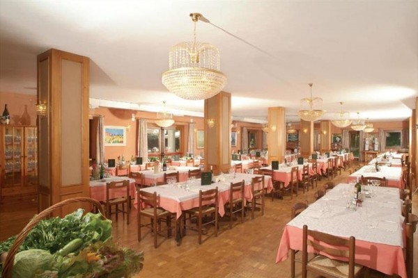 Restaurace s růžovými ubrusy a lustry na stropě.  